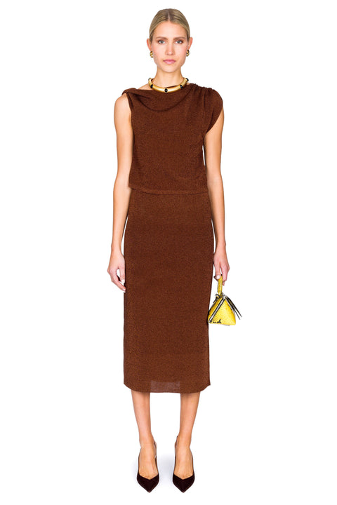Woman wearing a brown dress holding a yellow handbag on a white background posing head on