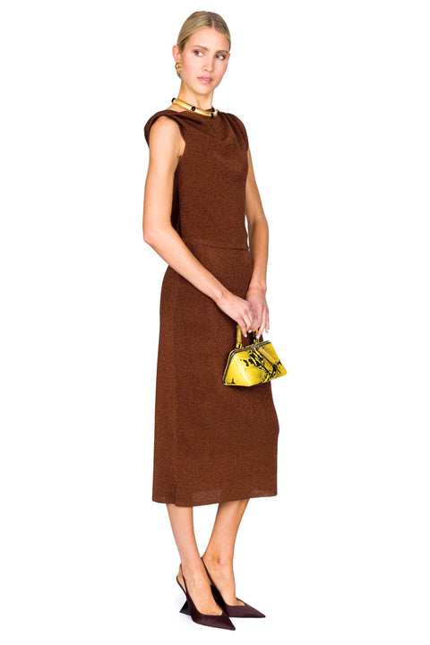Woman wearing a brown dress holding a yellow handbag on a white background posing to the side