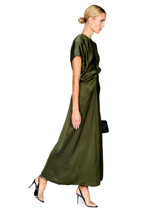 A woman modeling a floor-length olive green satin dress with short sleeves, shown in profile against a plain white background.