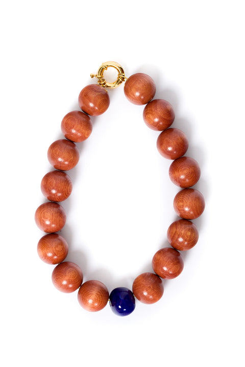 Necklace with brown beads and a blue accent bead on a white background