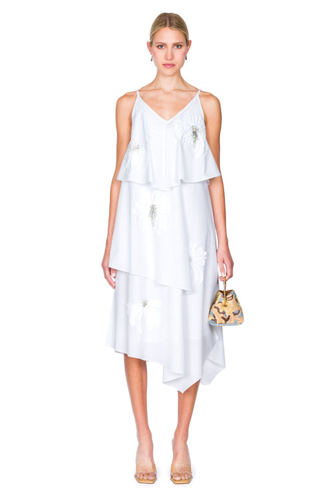 Woman wearing a white dress with a small multicolored handbag