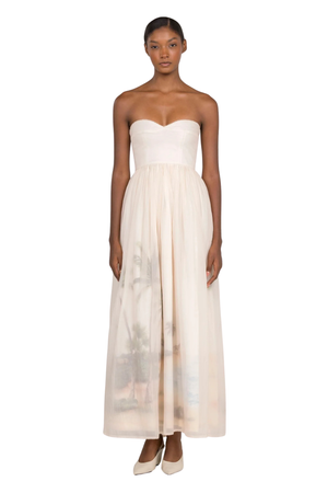 A woman wearing a cream strapless maxi gown with a sweetheart neckline on a white background