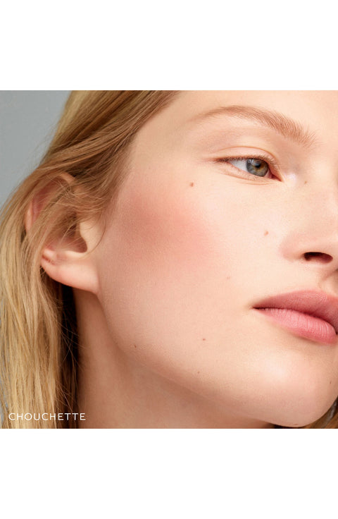 Model looking away while wearing the blush stick.  