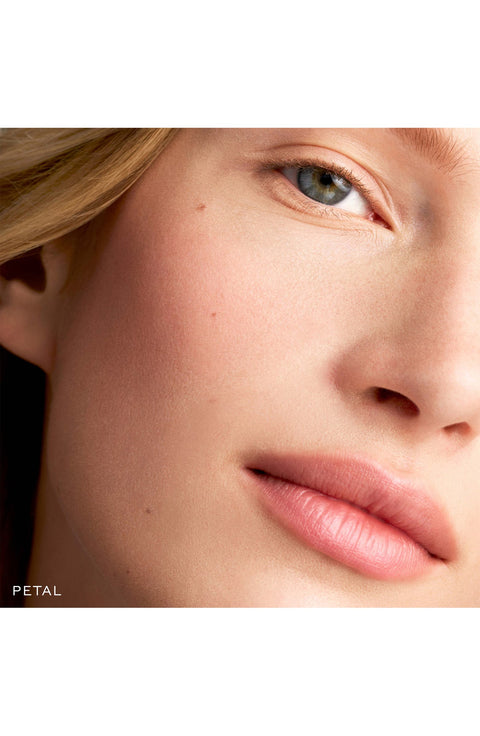 A model wearing the Baby Cheeks Blush Stick, facing forward.  